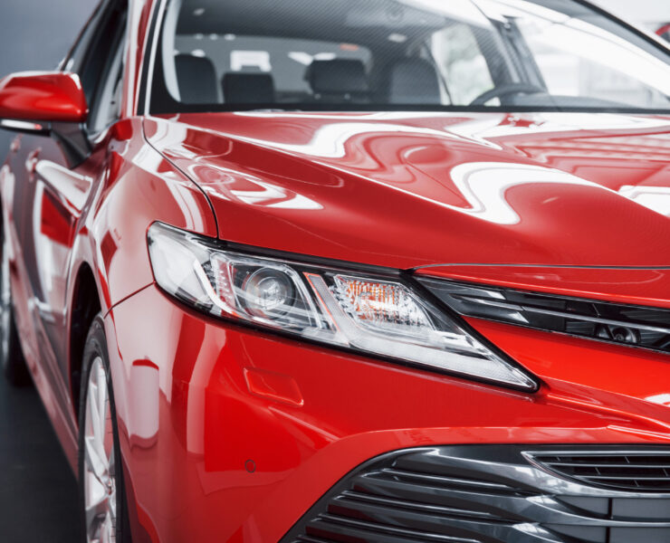 Headlights of the new red car, in the car dealership