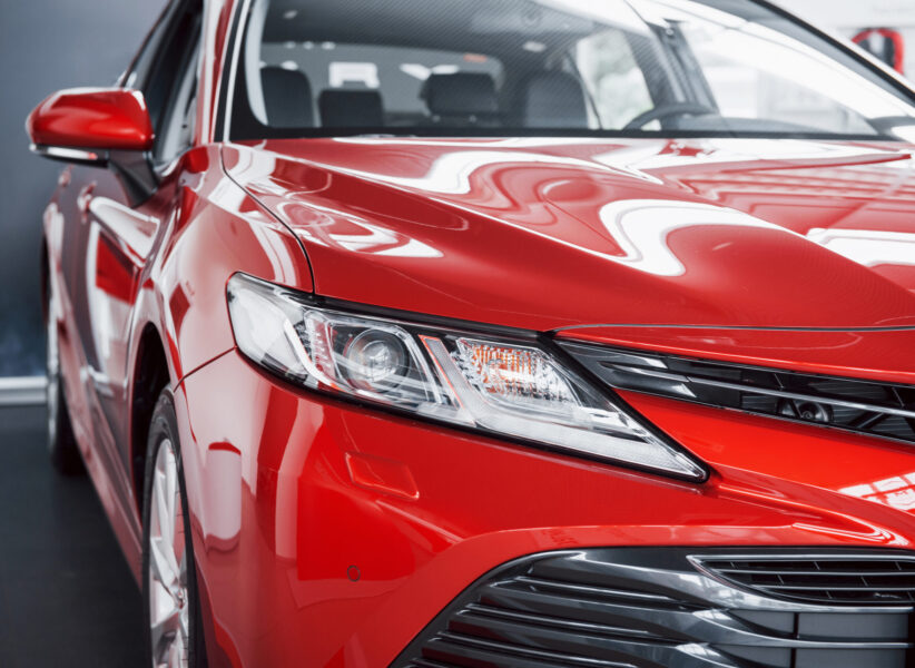 Headlights of the new red car, in the car dealership